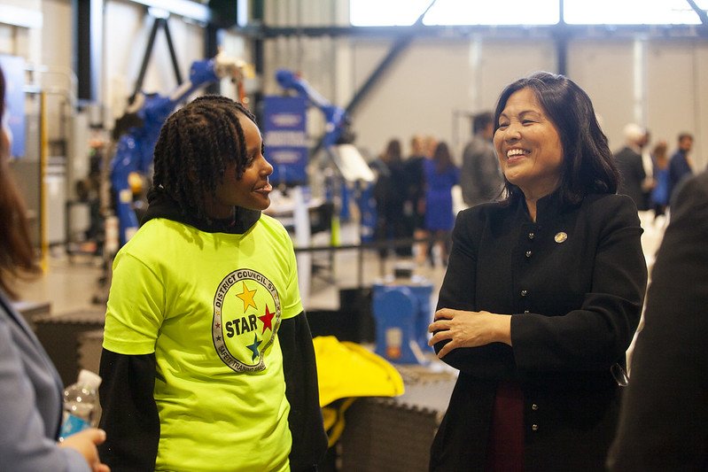 Acting US Secretary of Labor Julie Su smiles as she speaks with a young pre-apprentice.