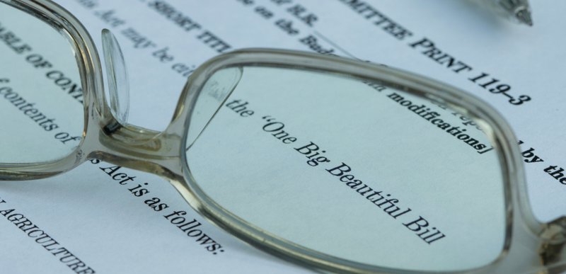 A pair of glasses rests on a Big Beautiful Bill